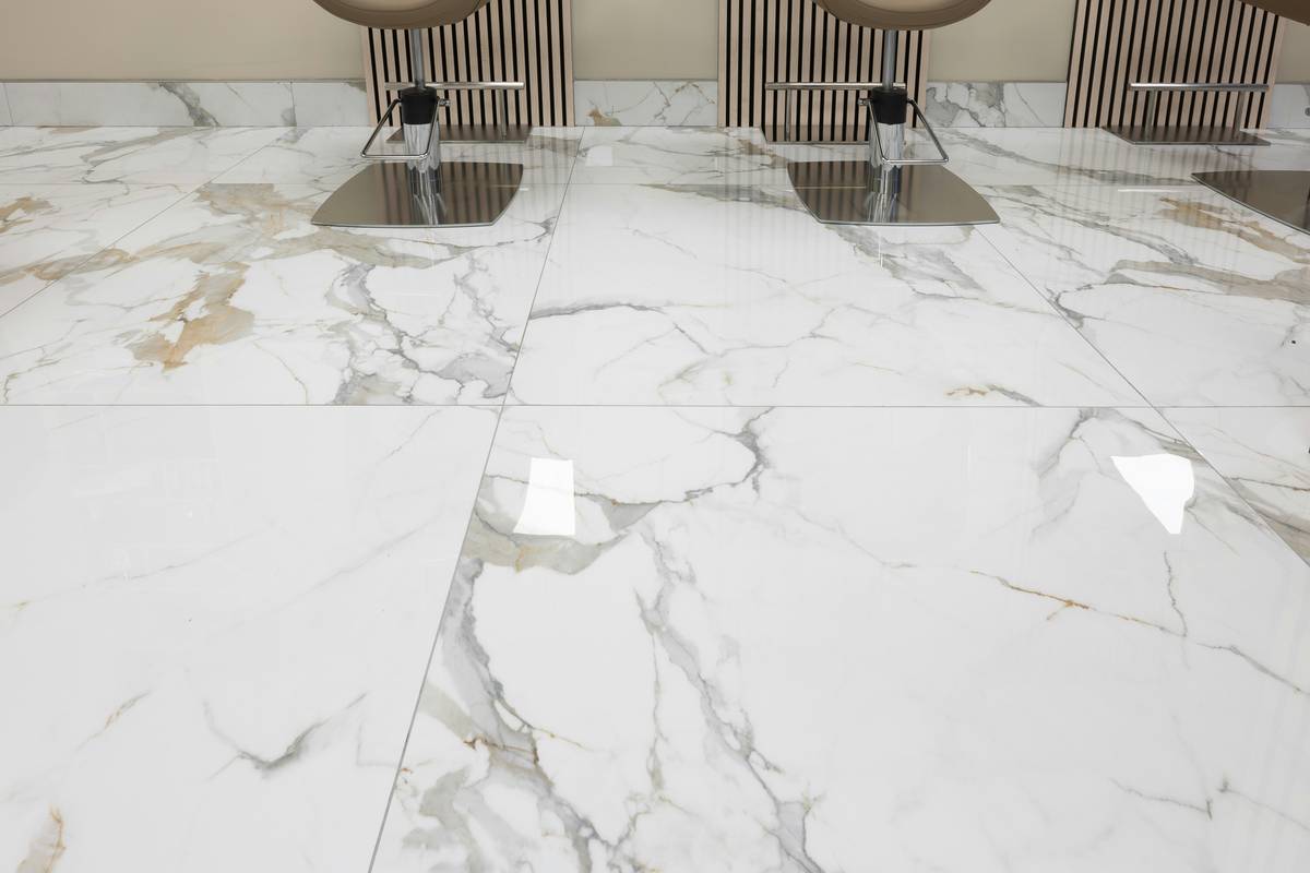 tiles and flooring materials showing porcelain tile samples in a sunlit showroom with measuring tape and moisture meter