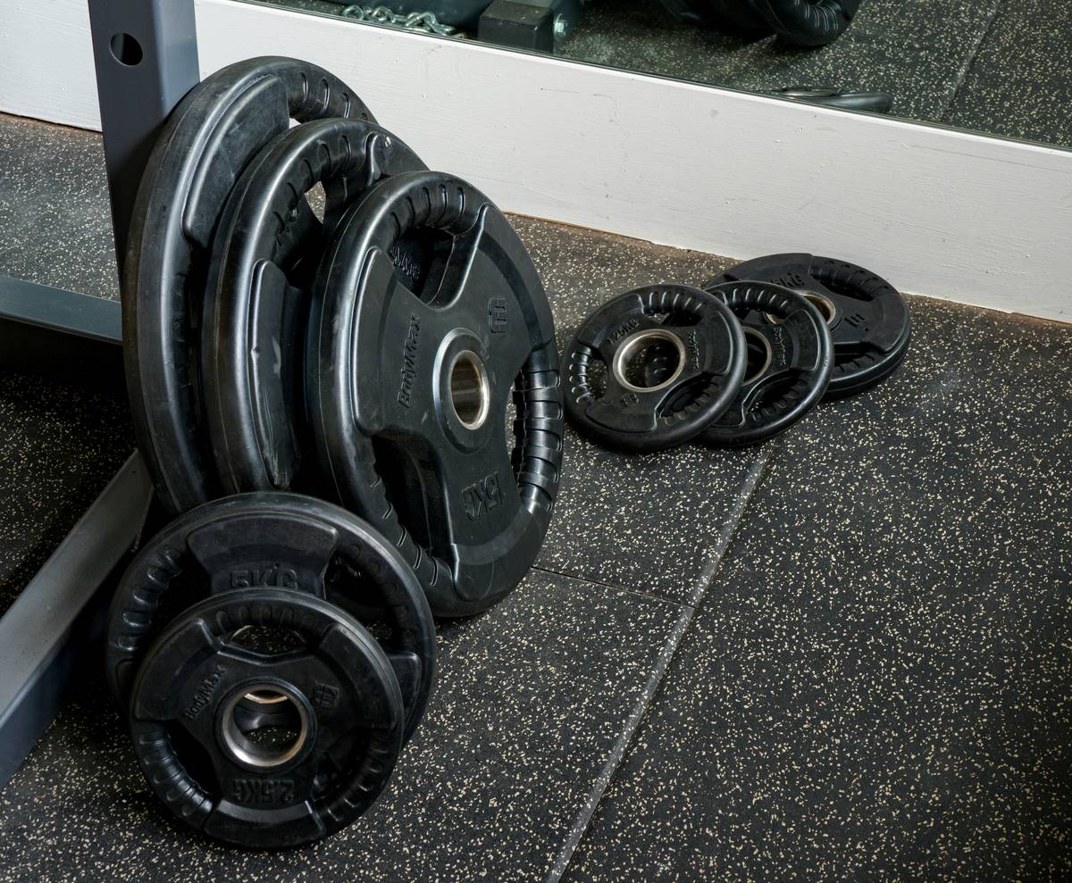exercise room floor tiles in matte gray porcelain with dumbbells and yoga mat on top